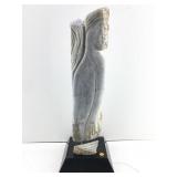A vintage hand carved stone sculpture depicting a