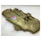 A solid cast brass tray depicting a lady lying