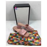 A used pair of Gucci, pink plastic slip on shoes