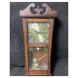 A vintage style wooden 31 day pendulum wall clock