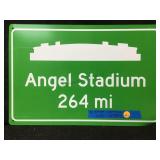 A custom green highway distance sign displaying a