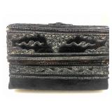 This is a dark, ornate metallic or repousse,