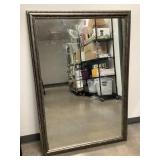 A large framed mirror in a wooden silver frame