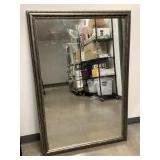 A large framed mirror in a wooden silver frame
