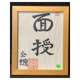 Framed calligraphy of Japanese symbols, displays