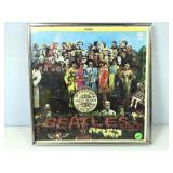 Framed under glass is a Beatles Sergeant peppers,
