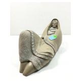 Handmade clay woman figure reclining on her back,