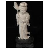 Ivory scrimshaw figurine on wood stand, measures