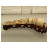 Bone scrimshaw mounted on wood stand, measures 7