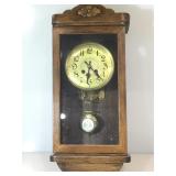 Vintage wood wall clock with key and pendulum.