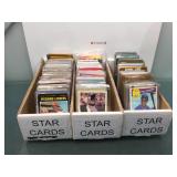 3 boxes of sports cards in sleeves with stars