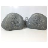 Two speaker rocks with wires.