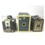 Three vintage box cameras. Two Kodak Brownie and