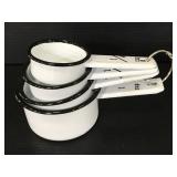 Four piece white and black metal measuring cups