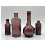 Four miniature purple amethyst glass bottles