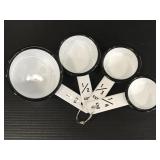 Four white metal measuring cups