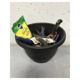 Outdoor planter full of assorted garden supplies