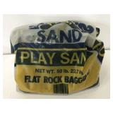 Partial bag of flat rock bagging play sand