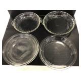 Four Pyrex glass pie dishes