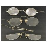 Three pairs of antique eyeglasses and hair pin