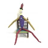 Odd folk art figure in wood chair