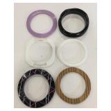 Five thick plastic bracelets and one wooden one