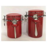 Two red Spiegel canisters with spoons