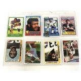 Eight assorted football cards in protective sheet