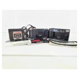 Three vintage cameras with user manuals