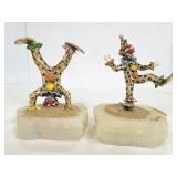 Two signed brass clowns on quartz