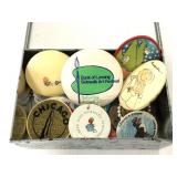 Tin container of assorted buttons, keychains, etc.