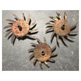 Three rusty old metal farm tiller blades