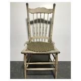 Old weathered white chair w/ braided seat cushion