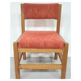 Wood chair with faded red upholstery