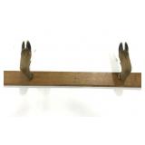 Mounted deer hooves coat rack on wood
