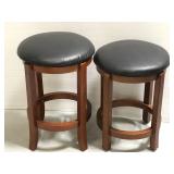 Two wooden stools with leather upholstered seats