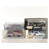 Four toy racing cars in boxes