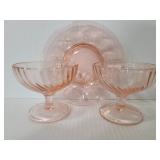 Two pink glass cups and small plates