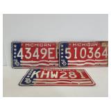 Three vintage patriotic Michigan license plates