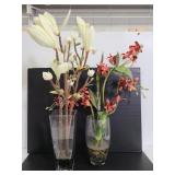 Two glass vases of faux flowers