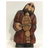 Vintage carved wood man playing instrument