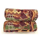 Two colorful abstract cylinder couch pillows