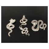 Four silver toned snake pendants