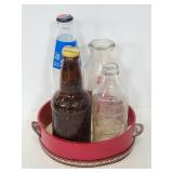 Four glass pop bottles with hand drum