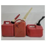 Three assorted plastic gas cans with spouts