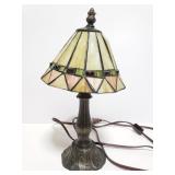 Small cast metal lamp with slag glass shade
