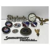 Collection of old car emblems, gauge and caps