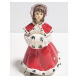 Woman in red coat ice skating figurine