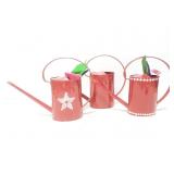 Three watering cans with gardening tools