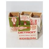 Four Detroit Edison labeled light bulbs